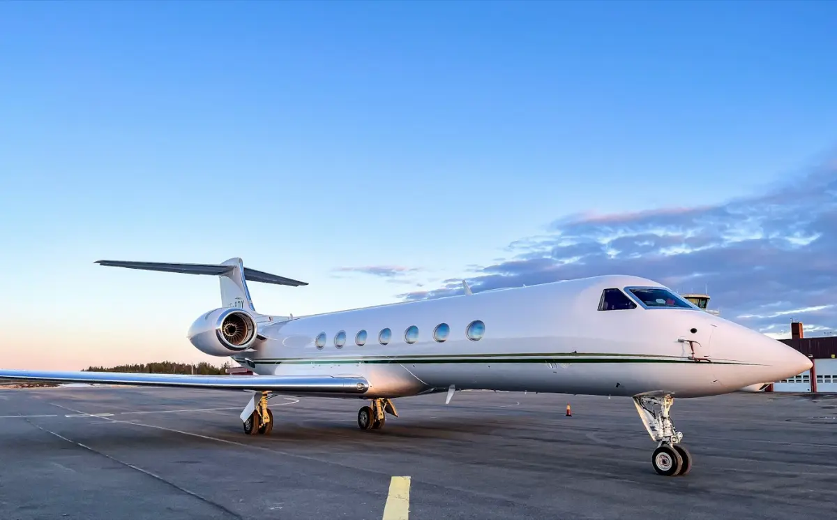 Jet privado en la pista de un aeropuerto al atardecer