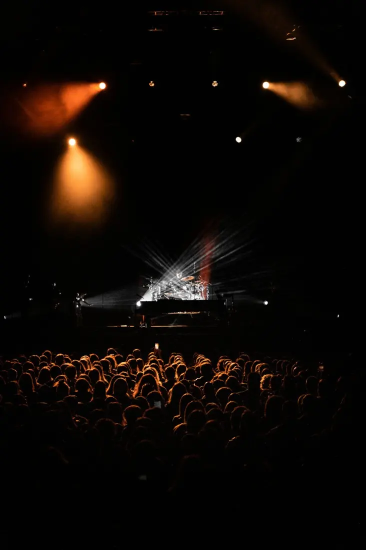 Sala de teatro a oscuras con el público mirando el escenario